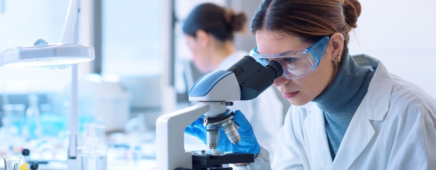 Clinical lab scientist looking into microscope