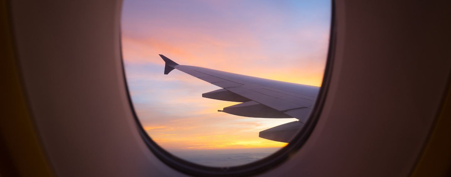 View from airplane window off the wing and a sunset sky