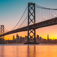 Bay Bridge at sunset, with the San Francisco skyline in the distance