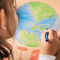 Child coloring a picture of Earth